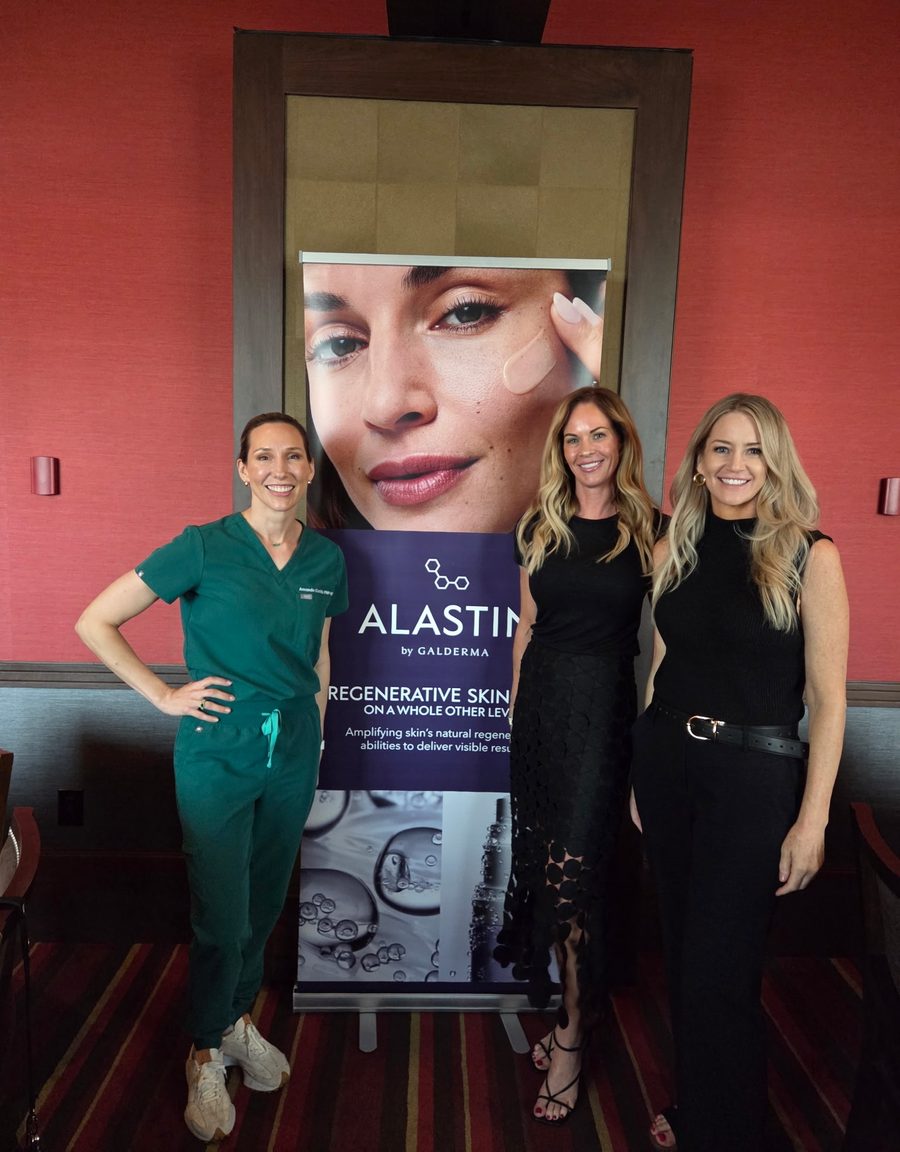 Amanda Curtis, FNP-BC, CANS, in green scrubs, standing with two other women in front of an Alastin banner
